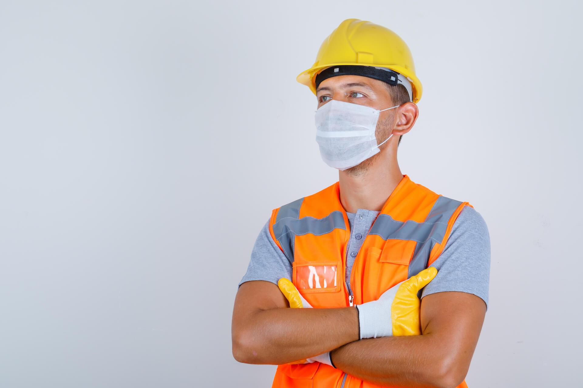 Builder in uniform with helmet, gloves and mask
